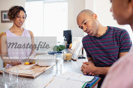 Family cooking and doing homework in kitchen