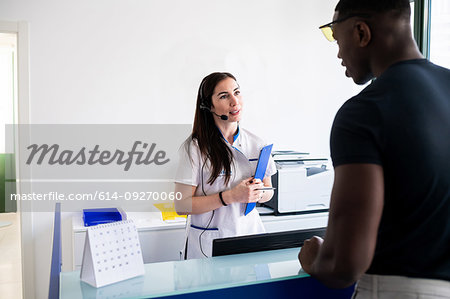 Nurse speaking with patient at hospital reception