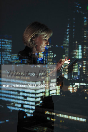 Double exposure businesswoman with smart phone against highrise lights at night