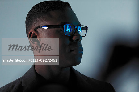 Double exposure businessman with reflection of AI text in eyeglasses