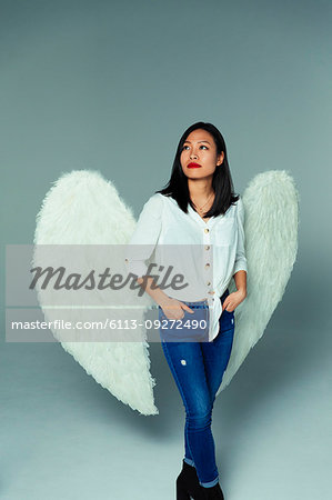 Portrait serene, thoughtful woman wearing angel wings