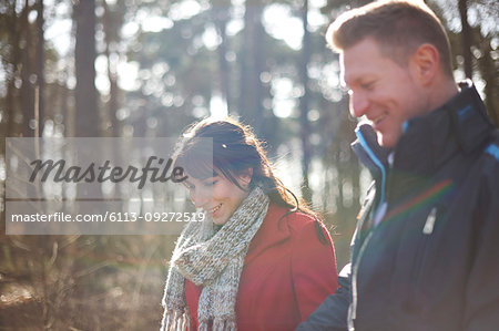 Couple hiking in sunny, autumn woods