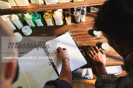 Male barbershop owner checking product inventory