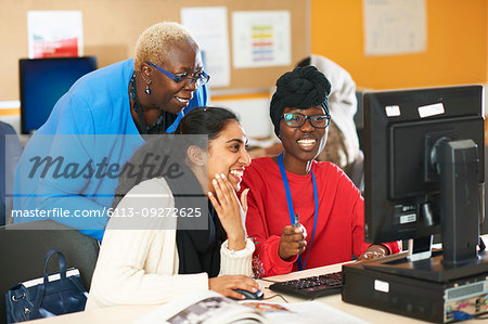 Female professor and college students using computer in computer lab