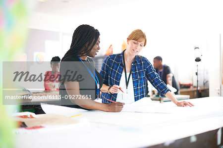 Female fashion designers drawing sewing pattern in studio