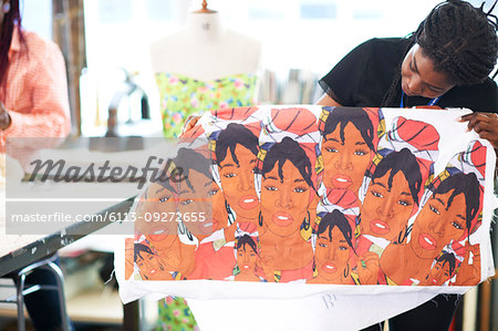 Female artist holding screen print in art studio