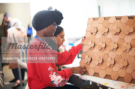 Female artist with 3D wood art in art studio