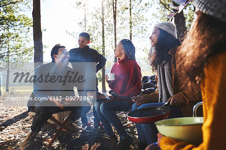 Family and friends eating at sunny campsite in woods Family and friends eating at sunny campsite in woods