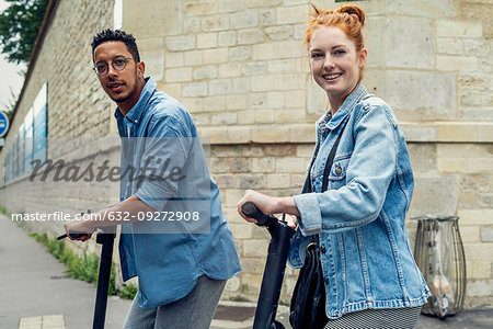 Couple standing with push scooters