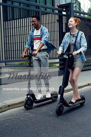 Couple riding push scooters