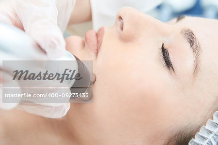 Cosmetic procedure. Microcurrent therapy for the face. Young girl.