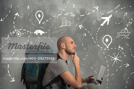 Explorer man plans a new travel with his laptop