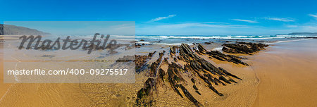 Rock formations on sandy beach (Algarve, Costa Vicentina, Portugal). Summer Atlantic ocean coast panorama.