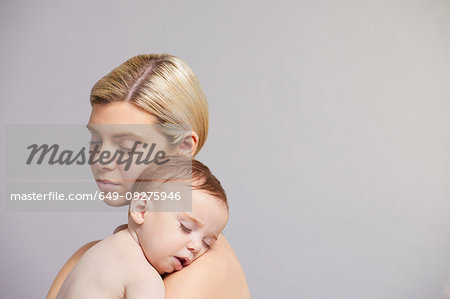 Mother with baby boy sleeping on shoulder