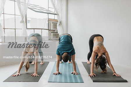 Friends practising yoga in studio