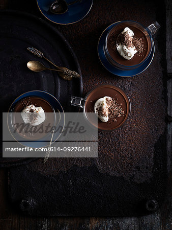 Rustic low key still life with coffee, chocolate truffle cups on table, overhead view