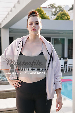 Woman in workout attire posing at swimming pool