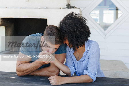 Man kissing woman's hand in beach house