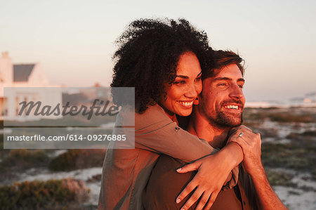 Couple enjoying view of sunset on beach