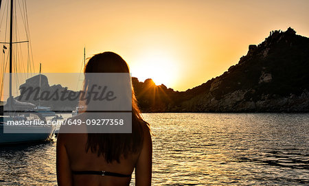 Woman enjoying sunset at sea, La Maddalena island, Sardegna, Italy