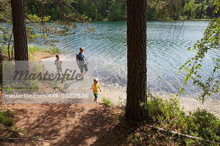 Father and sons playing near lake, Finland