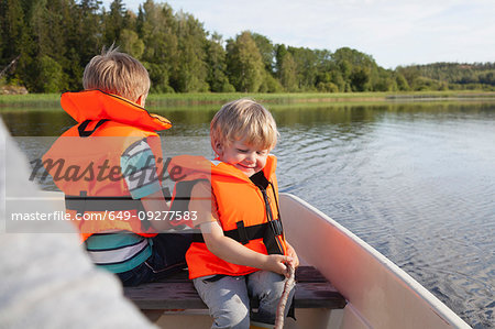 Adult sailing with boys on boat in lake, Finland