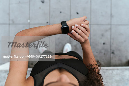 Young woman checking smartwatch outdoors