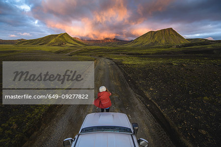 Woman traveller enjoying scenic view of volcanic mountains on vehicle, Landmannalaugar, Highlands, Iceland