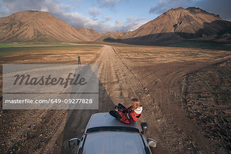 Woman traveller enjoying scenic view on vehicle, Landmannalaugar, Highlands, Iceland Woman traveller enjoying scenic view on vehicle, Landmannalaugar, Highlands, Iceland
