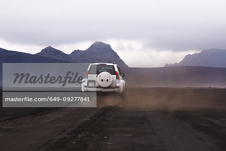 Off road vehicle on dirt track heading to hills, Landmannalaugar, Iceland