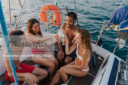 Friends toasting with champagne on sailboat, Italy