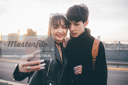 Young couple taking selfie on street, Milan, Italy