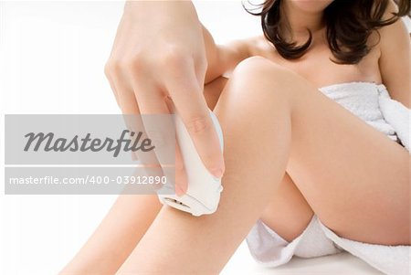 nice closeup of cute and young girl dressing white towel and shaving her legs