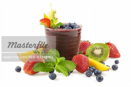 A glass of blueberry smoothie surrounded by fresh fruits
