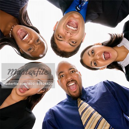 Low angle portrait  of multi-ethnic business group of men and women in huddle screaming.