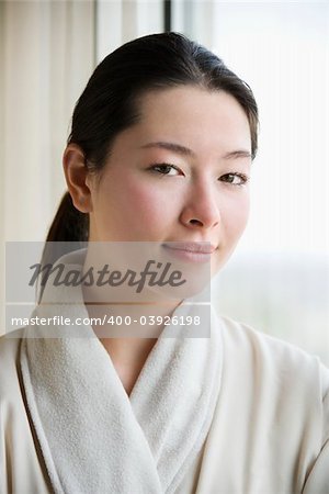 Taiwanese mid adult woman in bathrobe looking at viewer.