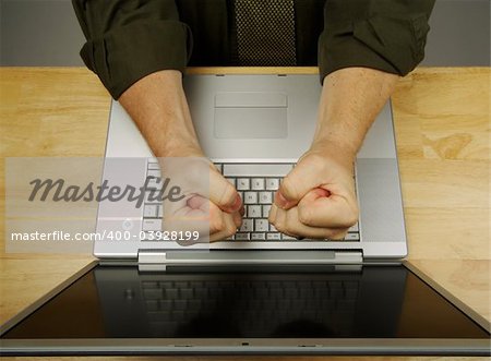Frustrated businessman shows his frustration while working on his laptop.