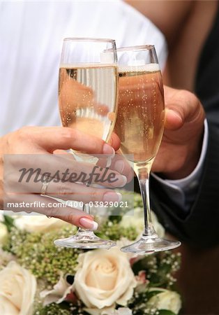 Glass of champagne in a hand of the groom and bride