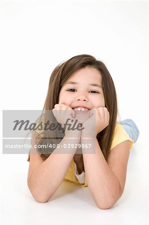 Five year old female child laying on white background smiling wearing casual clothes