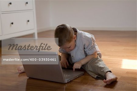 Child sitting on the floor learn how to use a pc