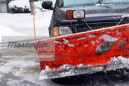 Snow plow truck on a road during a snowstorm