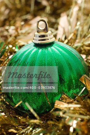 A grren christmas decoration with gold tinsel
