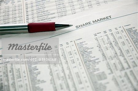 Pen resting on stock market financial data in a newspaper