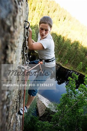 A climber at the top of a ledge looking down with fear.