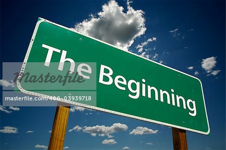 "The Beginning" Road Sign with dramatic blue sky and clouds.