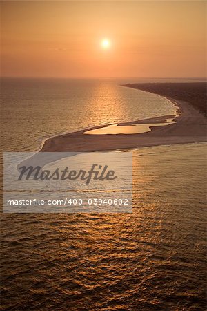 Aerial view of sun over Atlantic ocean and shoreline of Bald Head Island, North Carolina.