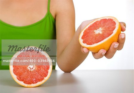 Close-up of a female hand holding a red grapefruit