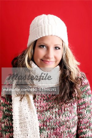 winter portrait of a beautiful young woman is freezing with a cap and a scarf