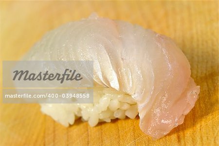 White fish sushi on a wooden board