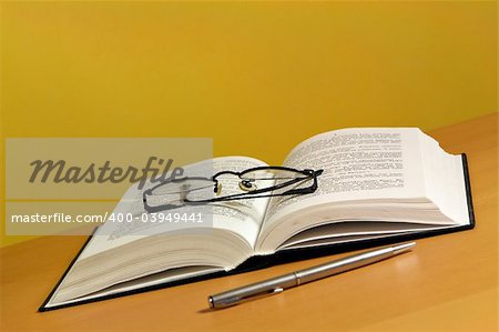 Open book with pen and glasses